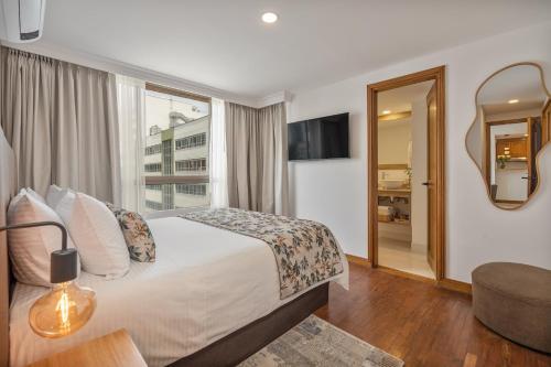 a hotel room with a bed and a mirror at Alcazar de Oviedo by EE Hoteles in Medellín