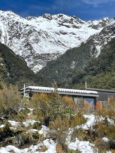 a building in front of a snow covered mountain at The Nook in Arthur's Pass