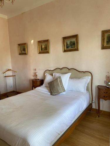 un lit avec des draps blancs et des oreillers dans une chambre dans l'établissement L'azura Villa Front De Mer Golf Juan, à Vallauris