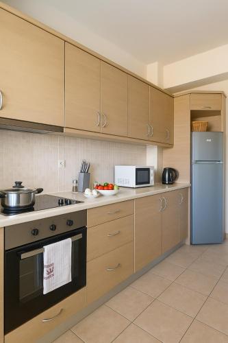 a kitchen with wooden cabinets and a refrigerator at Relax Private Pool House in Maleme