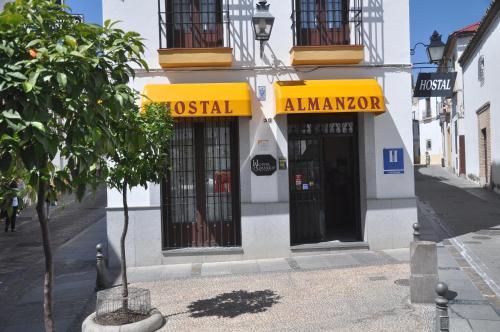 a building on a street with a tree in front of it at Hostal Almanzor in Córdoba
