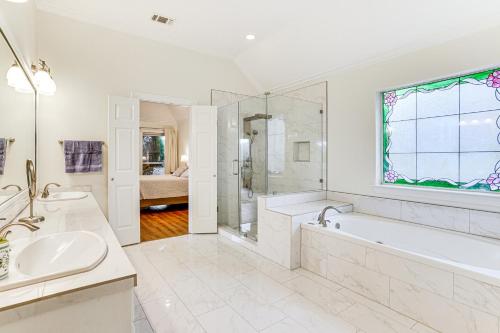 a white bathroom with a tub and a sink at Spacious Family Retreat in Fort Worth Area! in Aledo