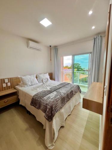 a bedroom with a large bed and a large window at Del Mar SG Apartment in Trairi