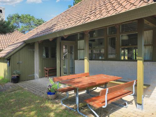 a picnic table and bench in front of a house at Inviting holiday home in Karrebæksminde in Karrebæksminde