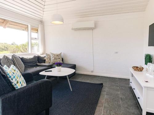 a living room with a couch and a table at Inviting holiday home in Karrebæksminde in Karrebæksminde