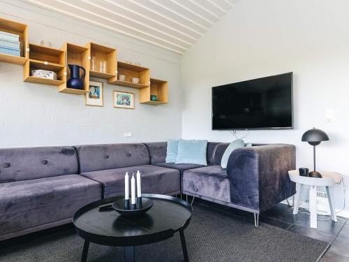 a living room with a purple couch and a tv at Inviting holiday home in Karrebæksminde in Karrebæksminde