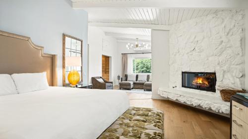 een slaapkamer met een groot bed en een open haard bij Pacific Crest Hotel Santa Barbara in Santa Barbara