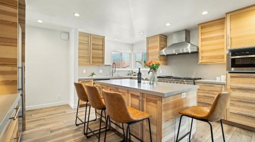 a kitchen with wooden cabinets and a island with bar stools at Pacific Crest Hotel Santa Barbara in Santa Barbara