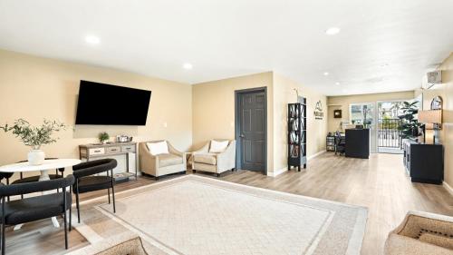 a living room with a television and a table at Pacific Crest Hotel Santa Barbara in Santa Barbara