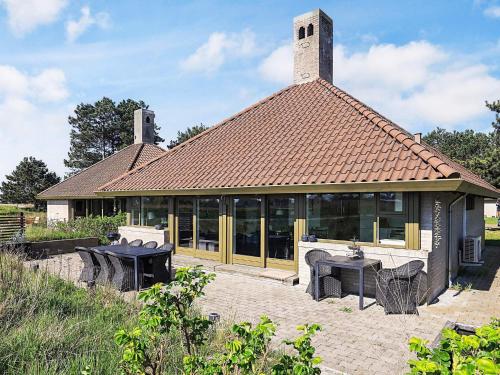 a building with a table and chairs in front of it at Holiday home Karrebæksminde LIII in Karrebæksminde