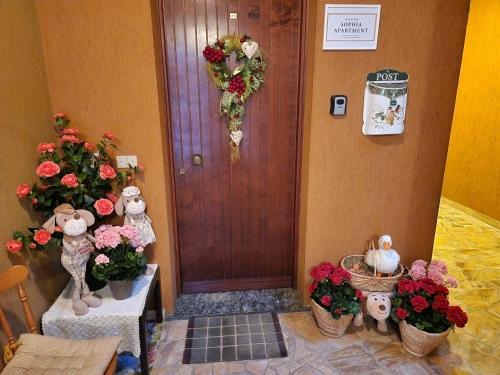 a hallway with flowers and a door with areath on it at Sophia Apartment Triora in Triora