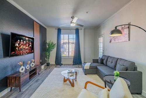 a living room with a couch and a tv at Elegant 1BD King Bed, Pool, Hot Tub, Gym, Parking in Glendale