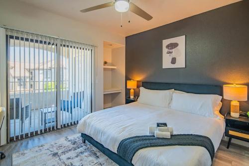 a bedroom with a large bed and a large window at Elegant 1BD King Bed, Pool, Hot Tub, Gym, Parking in Glendale