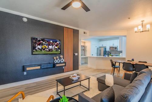 a living room with a couch and a tv on a wall at Relaxed 2BD King Bed Pool, Hot Tub, Gym, Parking in Glendale