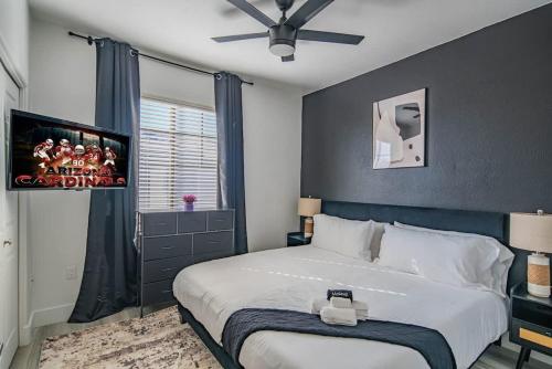a bedroom with a large bed and a flat screen tv at Relaxed 2BD King Bed Pool, Hot Tub, Gym, Parking in Glendale