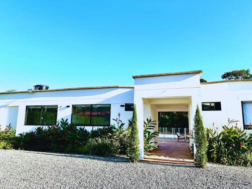 Una casa blanca con plantas delante de ella. en Cofradia Lodge, en Villavicencio