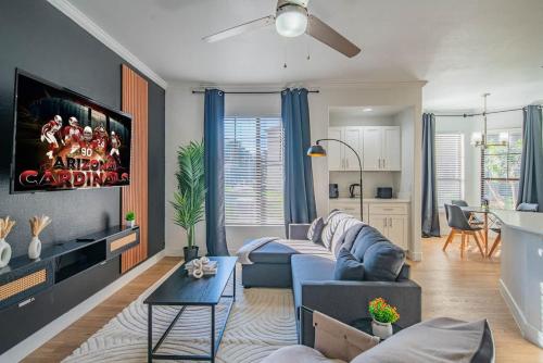 a living room with a couch and a tv at Chic 2BD King Bed with Pool, Hot Tub, Gym, Parking in Glendale