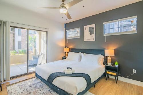 a bedroom with a large bed and a balcony at Chic 2BD King Bed with Pool, Hot Tub, Gym, Parking in Glendale