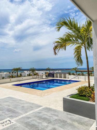 a swimming pool with a view of the ocean at Beautiful Celeste Condominium in La Paz
