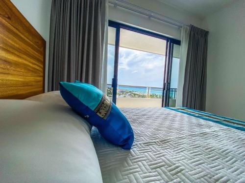 a blue shoe sitting on a bed in front of a window at Beautiful Celeste Condominium in La Paz