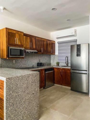 a kitchen with wooden cabinets and a stainless steel refrigerator at Beautiful Celeste Condominium in La Paz