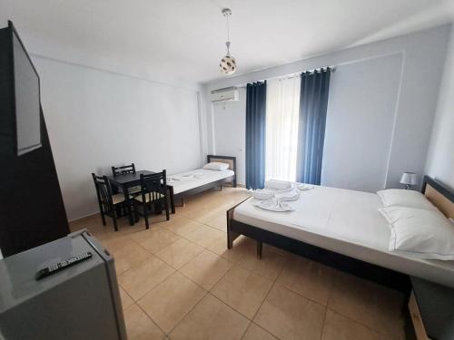 Un dormitorio con una cama grande y una mesa. en Vila Romeo, en Borsh