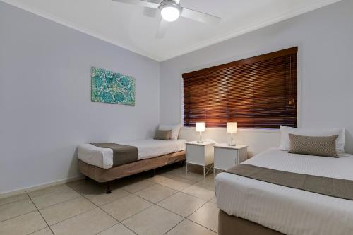 a hotel room with two beds and a window at Culgoa Point Beach Resort in Noosa Heads