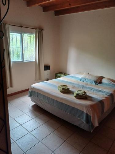 a bedroom with a large bed and a window at Casa Despertares - Las Rabonas in Mina Clavero