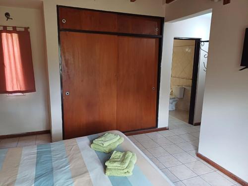 a bedroom with a bed and a wooden door at Casa Despertares - Las Rabonas in Mina Clavero