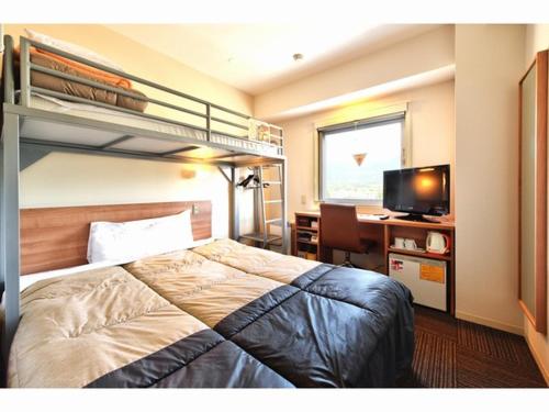 ein Schlafzimmer mit einem Etagenbett und einem Schreibtisch mit einem Computer in der Unterkunft Super Hotel Gotemba Nigo-Kan in Gotemba