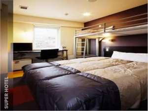 ein Schlafzimmer mit einem großen Bett und einem Schreibtisch in der Unterkunft Super Hotel Gotemba Nigo-Kan in Gotemba