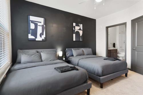 a bedroom with two beds and a black wall at Luxurious King 3 Bedroom Suite in North Raleigh in Wake Forest