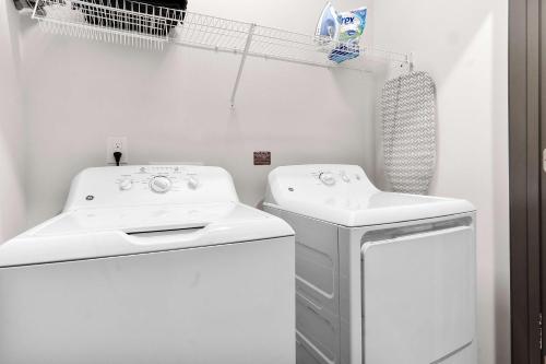 a white kitchen with a sink and a dishwasher at Luxurious King 3 Bedroom Suite in North Raleigh in Wake Forest