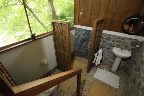 a bathroom with a toilet and a sink at Ave Sol River Sanctuary in Siquirres