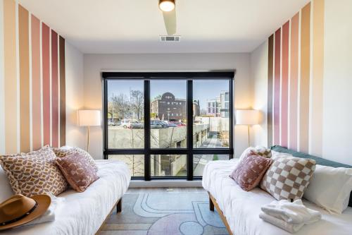 a living room with a couch and a large window at The Odyssey Apartments by AvantStay in Nashville