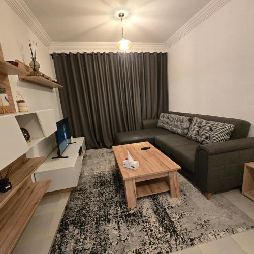 a living room with a couch and a coffee table at Appartement Confortable à Chouiter in Chouiter