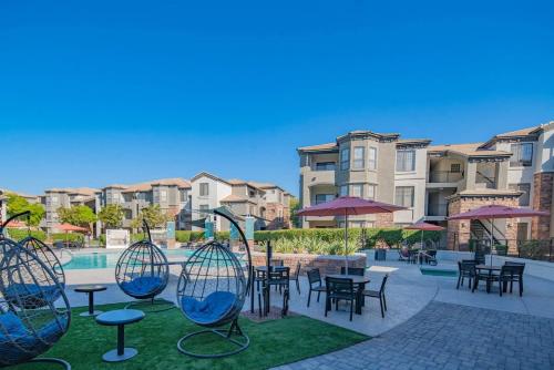 a courtyard with tables and chairs and a pool at Amiable 2BD King Bed with Pool, Hot Tub, Gym, Parking in Glendale