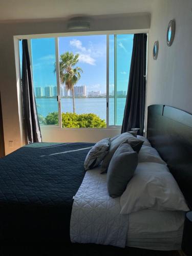 a bedroom with a bed with a view of the ocean at Hermoso departamento en zona hotelera frente a la laguna in Cancún