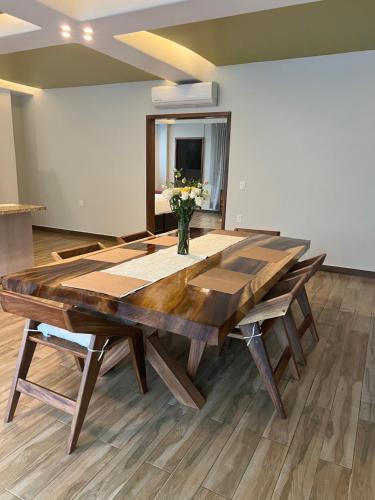 a dining room table with a vase of flowers on it at P V near Colomitos Beach Boutique Hotel in Puerto Vallarta