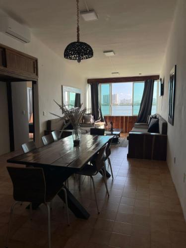 a dining room table and chairs in a living room at Hermoso departamento en zona hotelera frente a la laguna in Cancún
