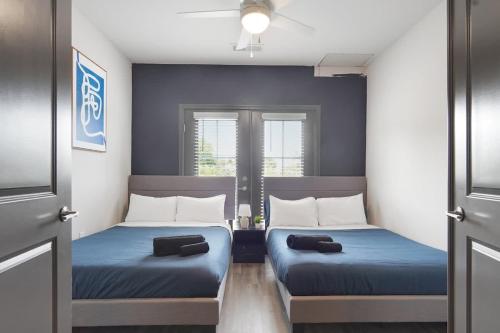 two beds in a small room with blue walls at Luxurious King 3BR Suitein North Raleigh! in Raleigh