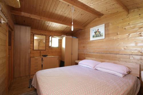 ein Schlafzimmer mit einem Bett in einer Holzhütte in der Unterkunft Secluded fisherman's cottage Cove Ducac, Brac - 24291 in Postira