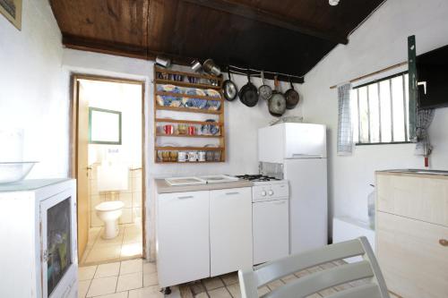 eine Küche mit weißen Schränken und einem weißen Kühlschrank in der Unterkunft Secluded fisherman's cottage Cove Ducac, Brac - 24291 in Postira
