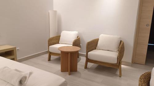 two chairs and a table in a room at Hotel Roca Bella in Es Pujols