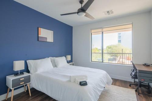 a blue bedroom with a bed and a desk and a window at Cozy 1BD - Pool, Gym, Parking, W-D - Sleeps 4 in Tempe