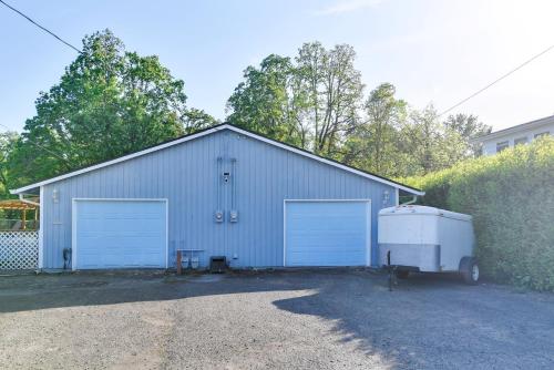 a large building with two garage doors and a trailer at Walk to Dtwn Milwaukie Family Gem with Creek Access in Milwaukie