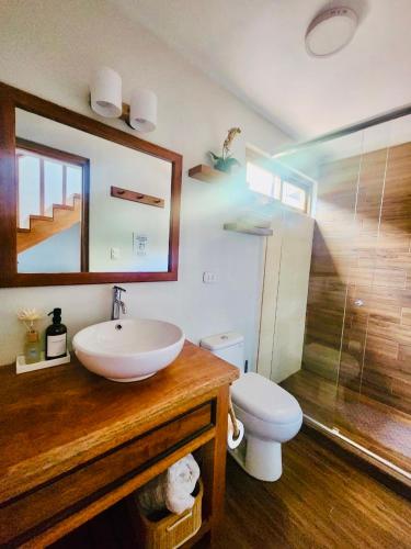 a bathroom with a sink and a toilet and a mirror at Tranquil creekside Bungalow in Sacred Valley Cusco in Cusco
