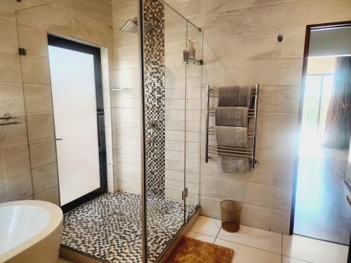 a bathroom with a shower with a glass door at The Green leaf Executive Home in Pretoria