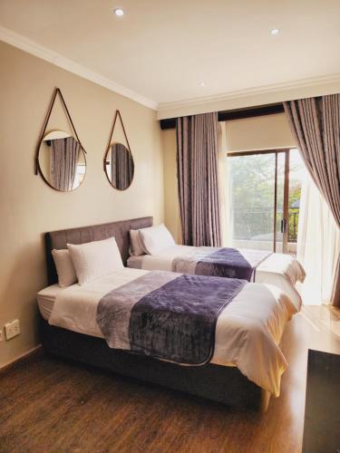 a hotel room with two beds and a window at The Green leaf Executive Home in Pretoria