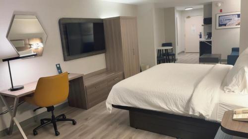 a hotel room with a bed and a desk and a television at Holiday Inn Express Hotel & Suites Drums-Hazelton by IHG in Drums